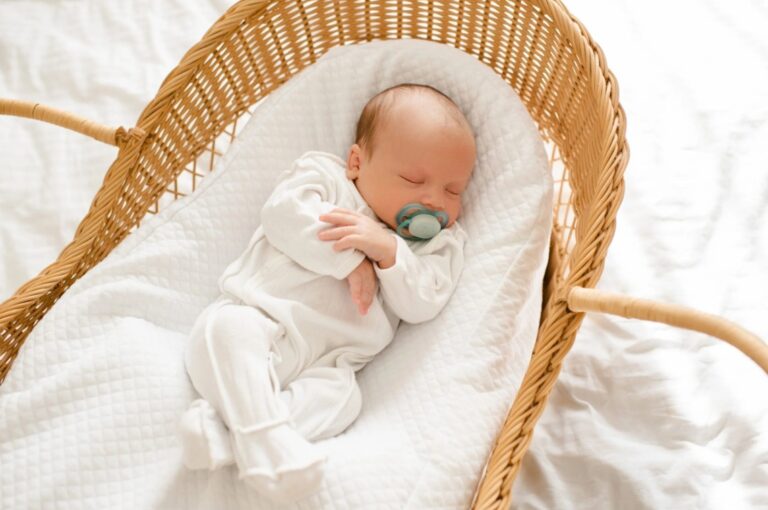 Calm Indian newborn sleeping peacefully in traditional cradle bassinet – baby sleep cries without waking explained