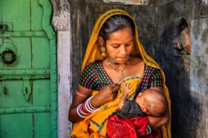 Indian mother breastfeeding newborn baby at home