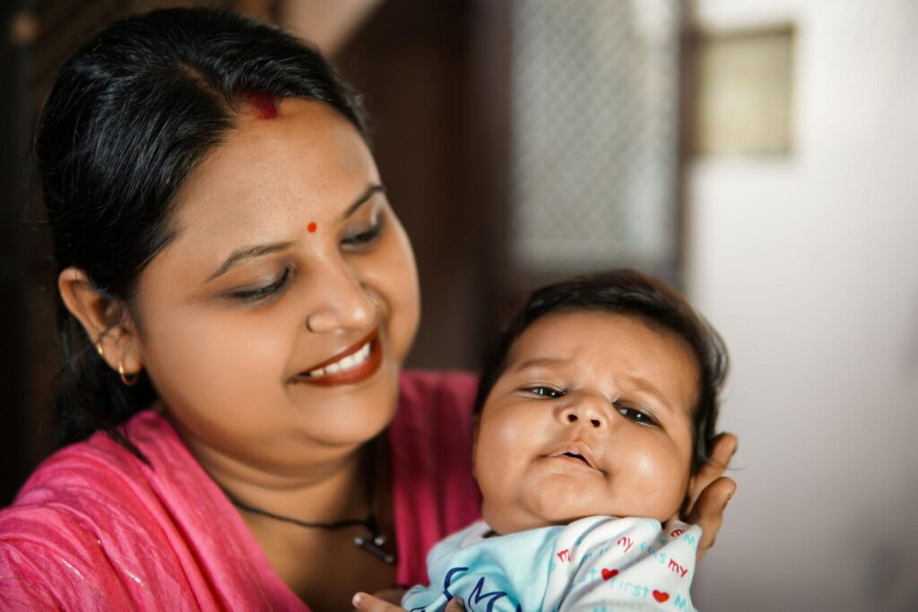 Indian mother breastfeeding newborn baby at home
